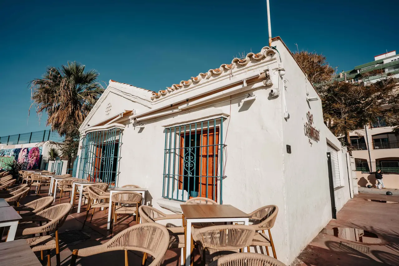 Fachada blanca de Casaamigos Playa con su terraza junto al paseo marítimo de Pedregalejo